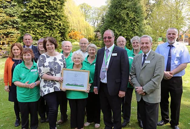 Mary Law, who chairs Cupar in Bloom, holds the award certificate, flanked by Liz Stewart, RHS Scotland manager and Keith Jackson, Fife Council parks and community events officer. Pictured also are some members of the bloom group and members of other organisations, who support the group. Pic by Dave Scott.