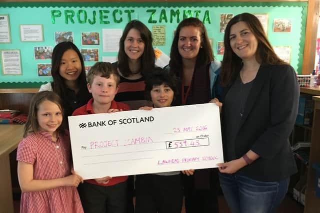 Pupils at Lawhead Primary School, St Andrews, handover the results of their fundraising to Project Zambia.