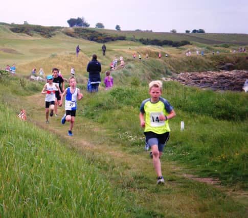 Hjalmar Struk (Unatt.) on the way to Under 11 boy's title at Kingsbarns chased by No. 49 Calum Gibson (Dundee Hawkhill) and leading girl No. 62 Isla Hedley (Fife AC).
