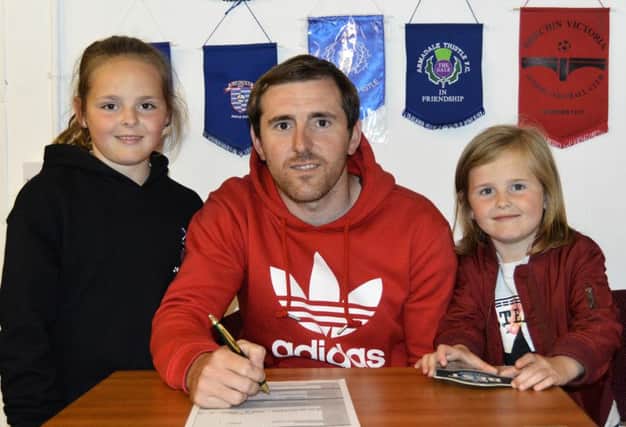 Watched on by daughters Ali and Krissy, Craig Johnstone signs back on at Treaton Park.