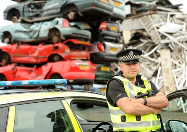 PC Richard Cartwright with crushed cars at Noble Recycling, Kirkcaldy. (Picture: Fife Photo Agency.)