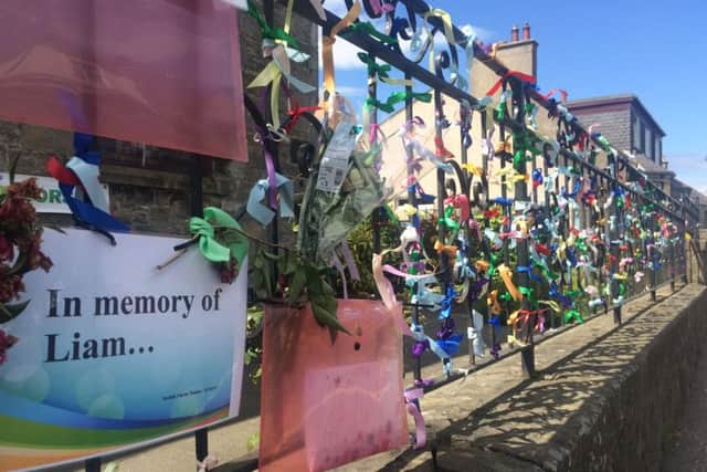 Tributes to Liam Fee tied to the chuch railings