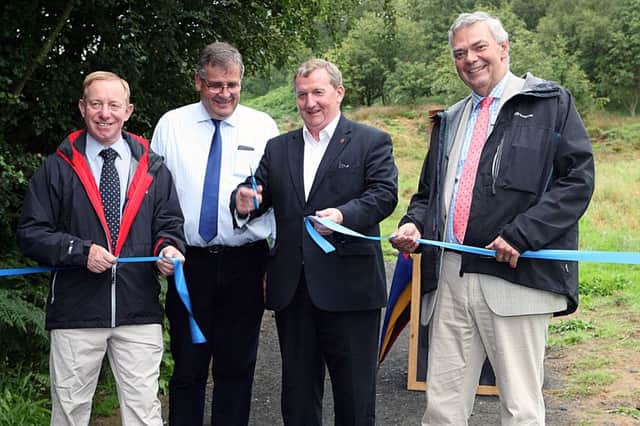 MSP Alex Rowley cuts the ribbon to open the path watched by, from left - Councillor Willie Robertson, George Lawrie of Living Lomonds and Stuart Housden, director of RSPB Scotland.