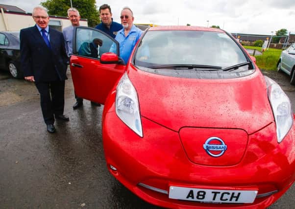 Councillors Bob Young and Tom Adams, from the councils regulation and licensing committee, with Neil and John Aitchison, of Aitch Taxis, and the company's first electric taxi.