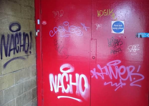 Grafitti on back doors of former Tesco store on Hill St