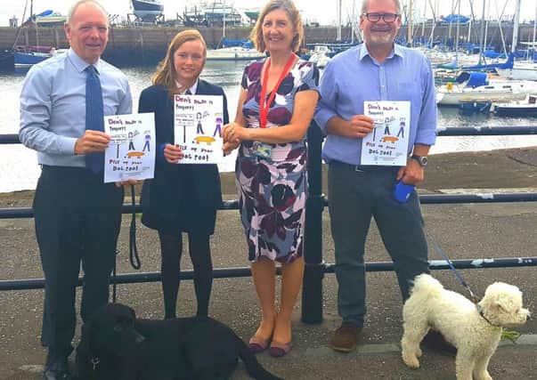Launch of the dog fouling campaign in Tayport. From left: Councillor Bill Connor,  Lara Manning, Jane Holmes (Headteacher,  Tayport Primary School),  Derek Gray (Vice Convener,  Tayport Community Council). Displaying the poster designed by Lara to deter dog fouling in the town.