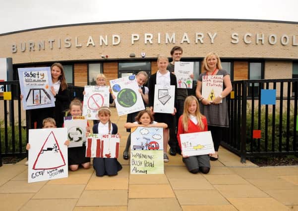 Pupils, with Julie Anderson and Ben Barron, display a range of the safety signs which will be put up around the town. Pics by FPA
