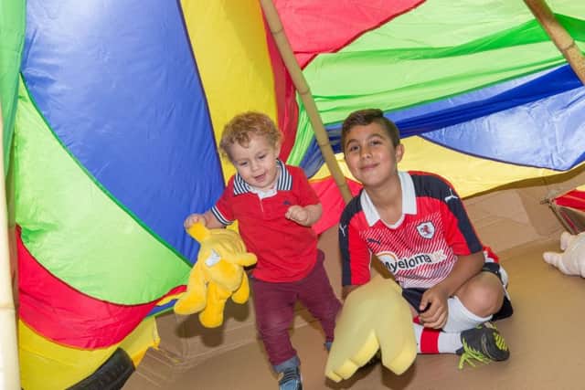 Kason Wallace (18 months)  plays in the tent with Akmal Greenlaw (10).