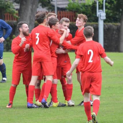AM Soccer Club's Harry Galloway is congratulated by team mates after netting.