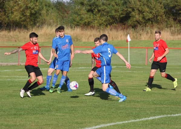 Tayport (in red) hold their line as Forfar go on the attack.