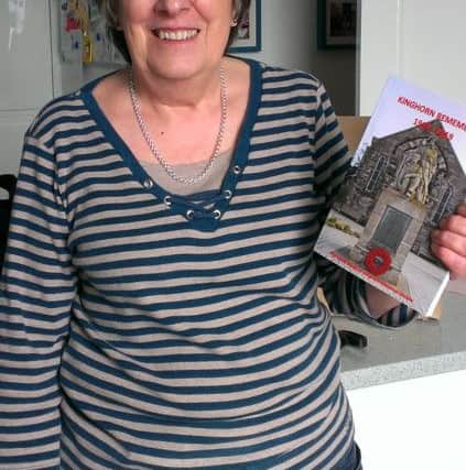 Ginny Reid with the book revealing the lives of the war memorial soldiers