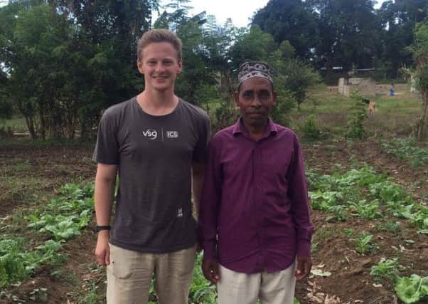 Former KHS head boy Alasdair Pilmer works with one of the farmers in Zanzibar