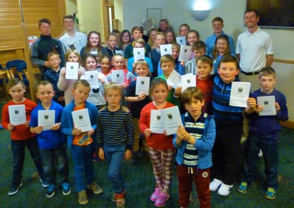 Crail junior golfers with their season review cards while  assistant professional David Snodgrass stands back left