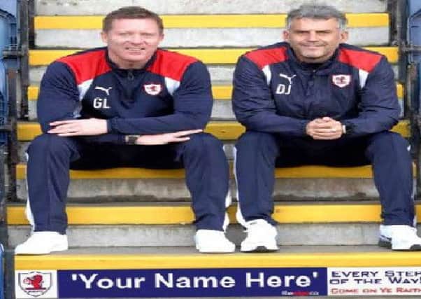Raith manager Gary Locke and assistant Darren Jackson promote the fact that Raith fans can now have their names printed on the steps at Stark's Park.