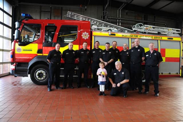 Ava at Lochgelly fire station with the red watch. Pic by David Wardle