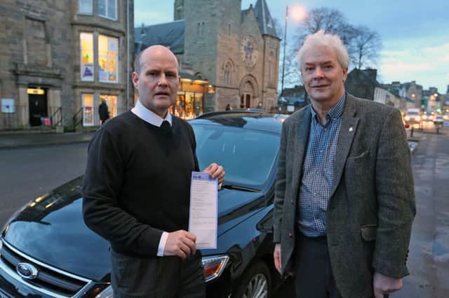 Steven Stewart (with his parking ticket) and Councillor Bryan Poole, beside Mr Stewart's car (Photo: Dave Scott)