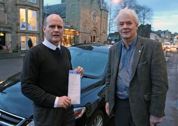 Steven Stewart (with his parking ticket) and Councillor Bryan Poole, beside Mr Stewart's car.