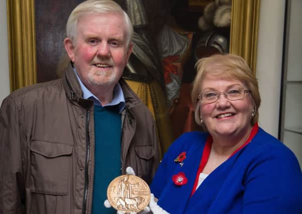 Ian Nimmo-White with Linda Ballingall from Glenrothes Heritage Centre and the 'Death Penny'.