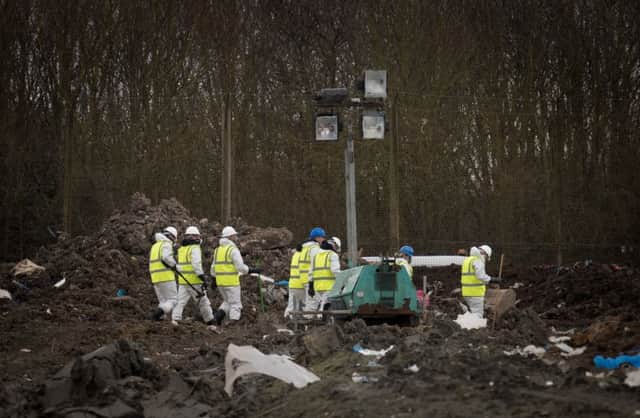 Police begin the grim task of searching the landfill site at Milton, near Cambridge.