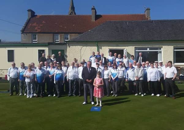 Leslie BC president Garry Campbell is pictured with his great-niece Zoe throwing the first jack watched by the some of the players.