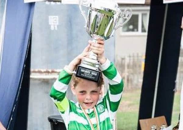 Nathan Melrose (9) holds the winners' trophy aloft at the Cupar Cup charity match