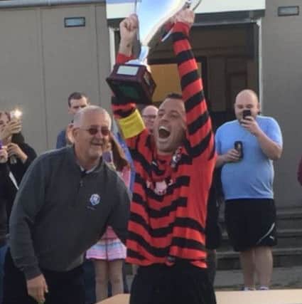Bowhill captain David Thomson lifting the league trophy