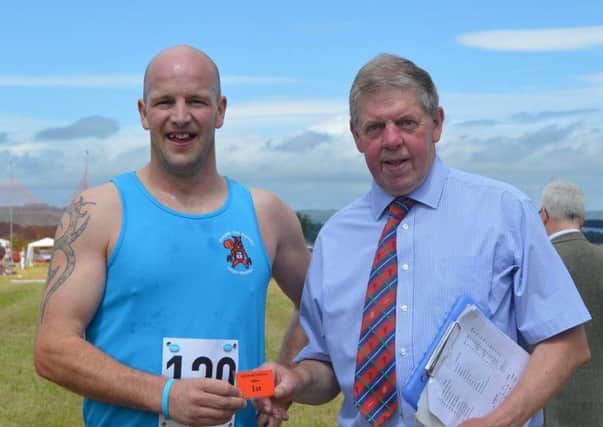 Mike Murdoch being presented with his winners prize at Newburgh Games by Gazette sports correspondent Shane Fenton.