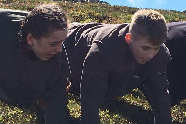 Daisy George on left and Josh Farmer on right performing polar press-ups in the heather at Glenmore Lodge after climbing a hill as part of The Polar Academy selection weekend. (Picture: The Polar Academy.)