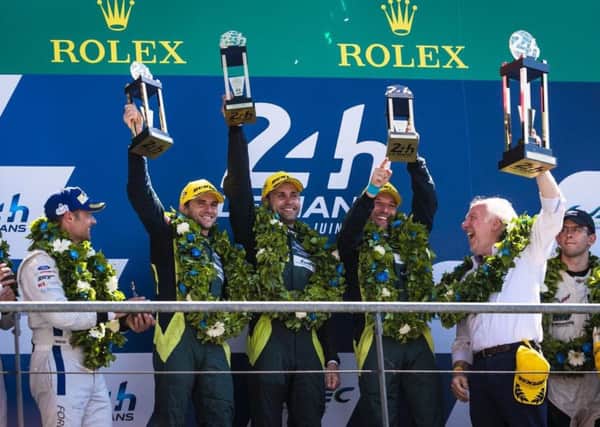 Jonny Adam (centre) holds aloft the Le Mans 24 Hour trophy flanked by his team mates.