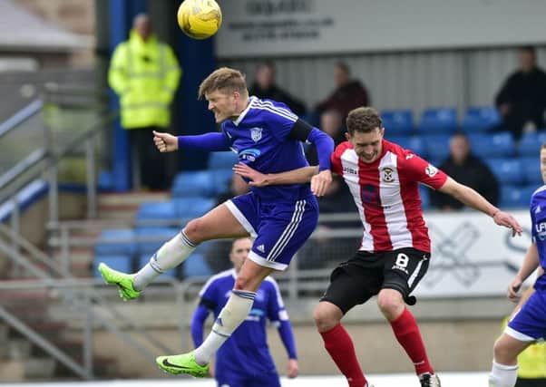 Peterhead's Willie Gibson heads clear from Pat Slattery. Pic by Dundan Brown.