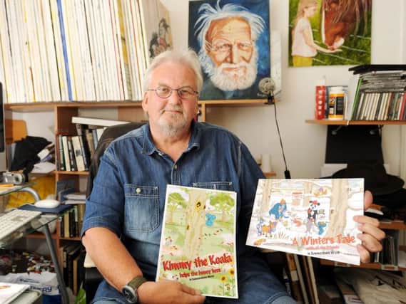 Graham Swan in his studio with two of his books. Pic by FPA