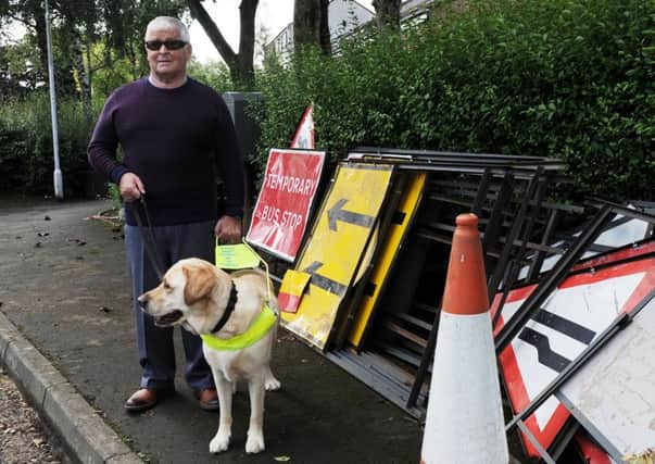 Ian Muir and his guide dog 'Tel' had their feet covered in hot tar. (Pic George McLuskie).