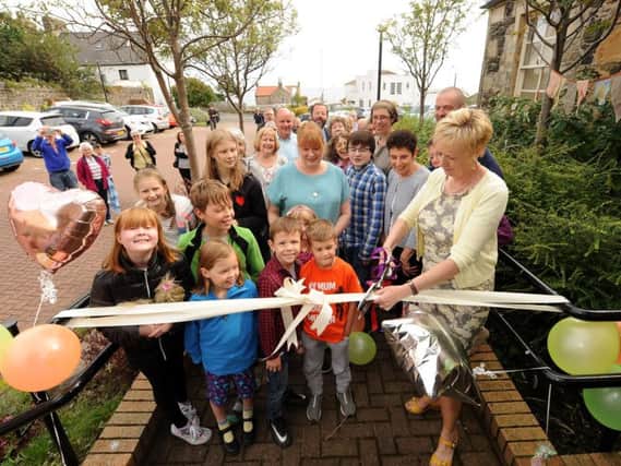 Elizabeth Whitton cuts the ribbon with local children. Pics by FPA