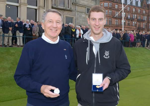 New R&A captain Bruce Mitchell, left, presents a Canadian Gold Maple Leaf coin to caddie Oliver Mennie (picture by the R&A).