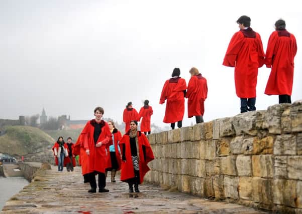Students from the University of St Andrews walk along the harbour wall  (Pic: Jane Barlow)