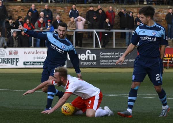 Raith boss Barry Smith felt his side should have had a penalty in Forfar for this trip on John Herron. Pic: Eddie Doig