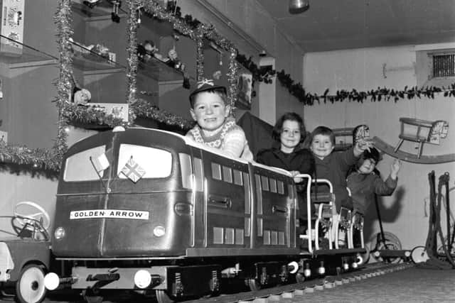 Festive flashback: Children play on the model of the Golden Arrow engine in Jenners Edinburgh 1965 (Pic: TSPL)