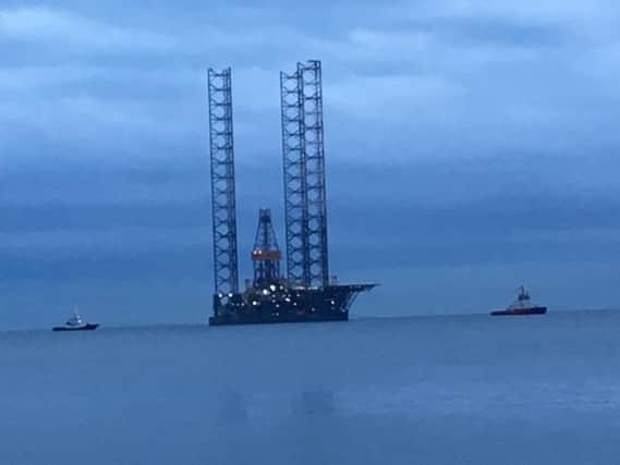 The oil rig is towed into place.