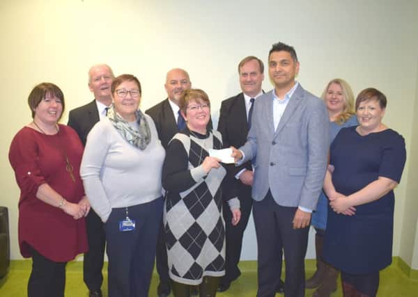 Anne McKain presents a cheque to respiratory consultant, Dr Devesh Dhasmana, and respiratory nurse consultant, Margaret Stevenson, flanked by his daughters and members of the Balgonie Masonic Lodge.
