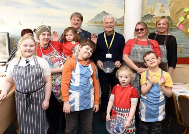 MSP  David Torrance, with Rod Cavanagh,  joins staff and volunteers at a cookery class.