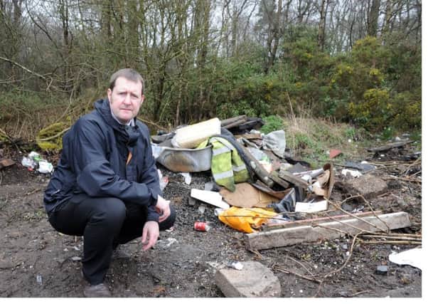 Fife Free Press reporter Neil Henderson surveys the fly tipping at Heatherywood. (Pic George McLuskie).