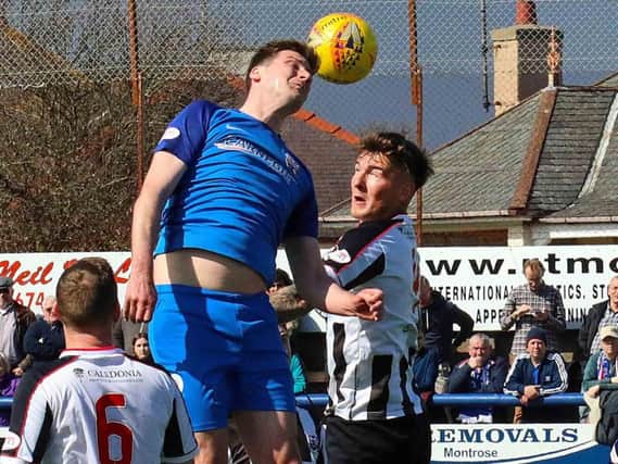 Chris Templeman challenges for the ball in the air against Elgin's Darryl McHardy (picture: Phoenix Photography)