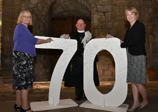 Tricia Marwick, chair NHS Fife Health Board, Rt Rev Dr Derek Browning, Moderator General Assembly Church of Scotland, and Shona Robison MSP, Cabinet Secretary for Health and Sport sign the 70 numbers marking the anniversary of the NHS.