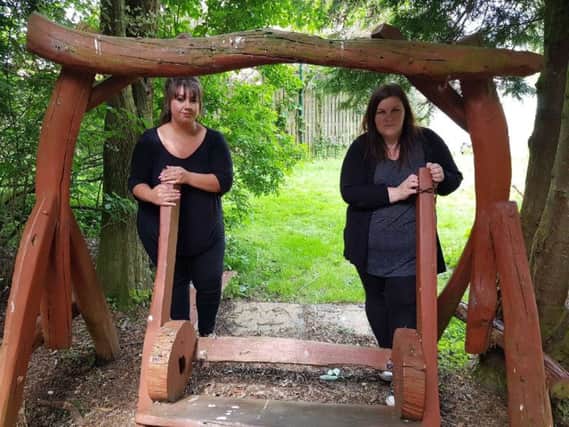 Kelly Rodgers (left) assistant manager and Kirsty Haston, children's support worker at the Cottage Family Centre with a swing which was vandalised in the fairy garden