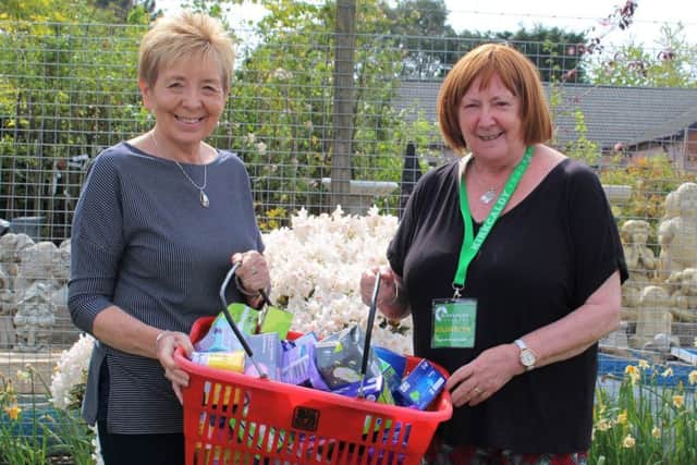 Maureen Closs (right) receives a donation for the foodbank's period poverty appeal from the programme action officer from the Soroptomists, April Eardley.