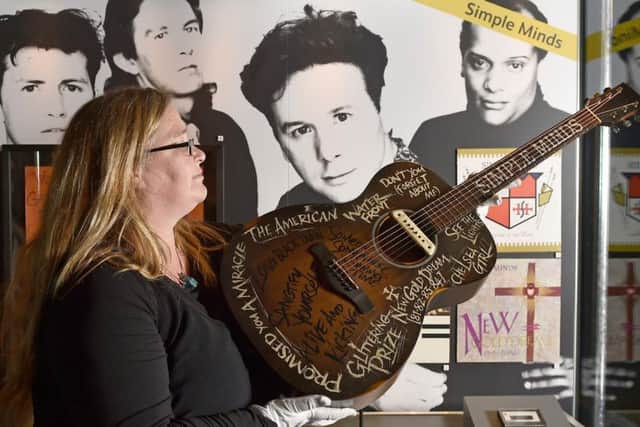 Vicky Brown, curator at National Museums Scotland, with a guitar on loan from Simple Minds. (Photo Neil Hanna).