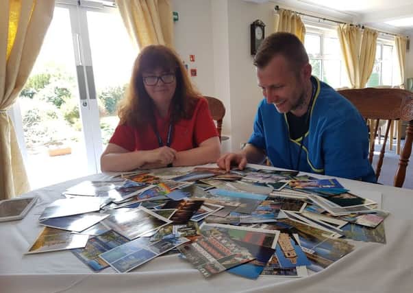 Manager Liam Duncan and activities co-ordinator Amanda McKidd look over the postcards.