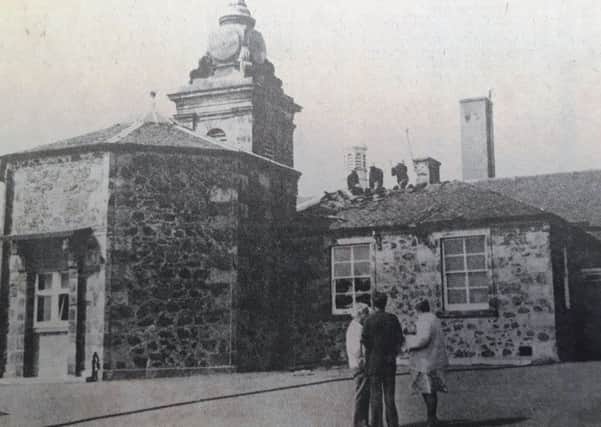 Firemen on the roof of Kinghorn PS after the fire in July 1980. In the foreground are Headmaster William Speed (left) with janitor Thomas Senior (right).