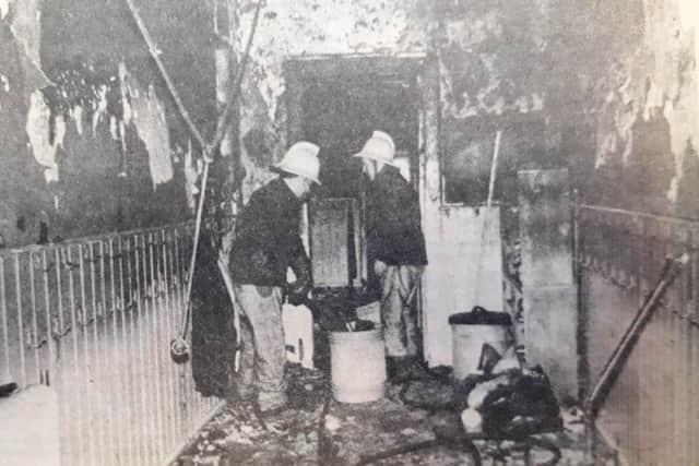 Firemen survey the damage to the school