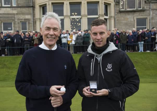 Chris Hilton, the new Captain of The Royal and Ancient Golf of St Andrews, presents a Gold Sovereign to caddie Oliver Mennie.